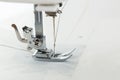 Close-up view of sewing machine needle and foot in action during fabric stitching process Royalty Free Stock Photo