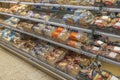 Close up view of shelves with variety of bread packed in plastic bags lying on shelves in supermarket.