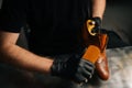 Close-up view of shoemaker in black gloves polishing light brown leather shoes with brush during restoration working. Royalty Free Stock Photo