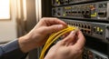 Technician s hands carefully connecting bright yellow network cables to a server rack with blinking lights Royalty Free Stock Photo
