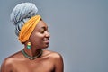 Close up view side portrait of cheerful young african woman smiling against gray background Royalty Free Stock Photo