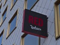 Close-up view of a sign with logo of hotel chain Radisson Red on the facade of a modern building in Vienna, Austria.