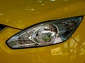 close up view of silver color headlight lens. yellow shiny modern car detail Royalty Free Stock Photo