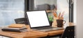 Close up view of simple workplace with laptop computer, notebook, coffee cup and stationery on wooden table Royalty Free Stock Photo
