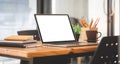 Close up view of simple workplace with laptop computer, notebook, coffee cup and stationery on wooden table Royalty Free Stock Photo