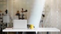 Close up view of workspace with laptop, office supplies, coffee cup and copy space on white table with blurred office room Royalty Free Stock Photo