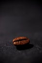Close-up view of a single coffee bean lying on a dark stone surface Royalty Free Stock Photo