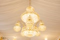 Close up view of single hanging luxury chandelier with white curtains ceiling