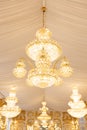 Close up view of single hanging luxury chandelier with white curtains ceiling