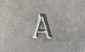 Close-up view of a single one letter A carved into a smooth gray stone. Latin alphabet letters, written language history, culture Royalty Free Stock Photo