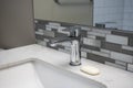 Close up view of a sink faucet inside an upscale bathroom, with a bar of soap on the counter beside it Royalty Free Stock Photo