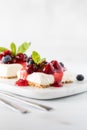 Close up view of slices of cherry cheesecake garnished with cherries, blueberries and mint.