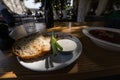 Close up view slices of smoked bacon meat with rye whole grain black bread, green onion and sour cream on the table. Royalty Free Stock Photo