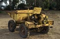 Close-up view of small beat up old yellow dumper truck. The vehicle with many scratches