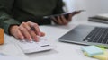 Small business entrepreneur using calculator checking order on digital tablet.