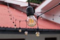 A small LED bulb that resembles a globe with orange filaments and clear amber glass