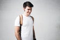 Close-up view of smiling man wearing white t-shirt and backpack