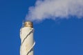 Close up view of smoke coming out of chimney against blue sky. Ecology and greenhouse effect concept. Royalty Free Stock Photo