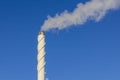 Close up view of smoke coming out of chimney against blue sky. Ecology and greenhouse effect concept. Royalty Free Stock Photo