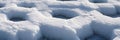 Close up view of a snow covered surface with geometric patterns and dark openings in the snowscape Royalty Free Stock Photo