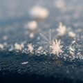 A close-up view of a snowflake resting on a dark, textured surface Royalty Free Stock Photo