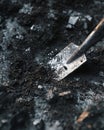 Close-up view of soil being expertly broken up with a trowel to prepare for planting seeds in a garden. Generative AI