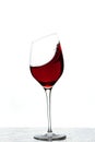 Close up view of splashing red wine in glass isolated on white background Royalty Free Stock Photo