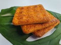 Close up view of a stack of crackers biscuit on an ornamental green monstera leaf.