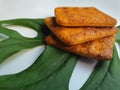 Close up view of a stack of crackers biscuit on an ornamental green monstera leaf. Royalty Free Stock Photo