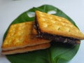 Close up view of a stack of crackers biscuit on an ornamental green monstera leaf. Royalty Free Stock Photo