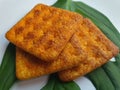 Close up view of a stack of crackers biscuit on an ornamental green monstera leaf.