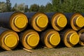 Close up view of a stack of large industrial water pipes with thick insulation covering for building in cold regions