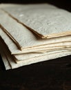 Close-up view of a stack of textured, handmade paper sheets on a dark wooden surface Royalty Free Stock Photo