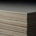 A close-up view of a stack of thick, gray-brown cardboard sheets. The edges are clea Royalty Free Stock Photo