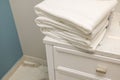 Close-up view of stack of towels on white nightstand in hotel bathroom