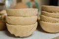 Close up view - unfinished clay plates on shelf of pottery workshop