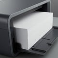 A close-up view of a stack of white printer paper partially loaded into a dark gray inkje Royalty Free Stock Photo