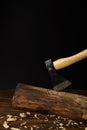 close up view of sticking axe in log and wooden chips on black background Royalty Free Stock Photo
