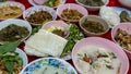 Close-up view of sticky rice, curry, laab, stir-fry and many other dishes packed in bowls
