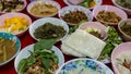 Close-up view of sticky rice, curry, laab, stir-fry and many other dishes packed in bowls