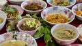 Close-up view of sticky rice, curry, laab, stir-fry and many other dishes packed in bowls