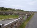 Close up view of stone walls and fence gates along a rural paved road in western Ireland Royalty Free Stock Photo