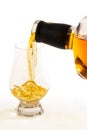 A close up view of straight bourbon whiskey being poured into an official whiskey glass - portrait view