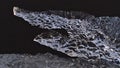 Close-up view of iceberg with clear ice surface shimmering in the evening sun in the black sand of diamond beach in Iceland.