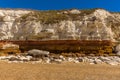 A view of the stratified white, red and orange layers and recent rock falls on the cliffs of Old Hunstanton, Norfolk, UK Royalty Free Stock Photo