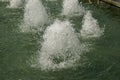 Close-up view of streams of fountain with reflection and lens flare. Water jet. City fountain. Water pressure. How to survive the Royalty Free Stock Photo