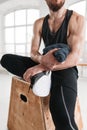 Close up view on strong male athlete resting on wooden box after cross intense in workout gym Royalty Free Stock Photo