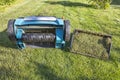 Close up view of a summer lawn with an electric aerator with a basket of mown grass. Gardening machines concept.