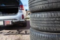 Close up view of summer tire with open trunk of passenger car, seasonal wheel change