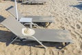 Close up view of sun hat on empty sun lounger on sand beach. Greece.